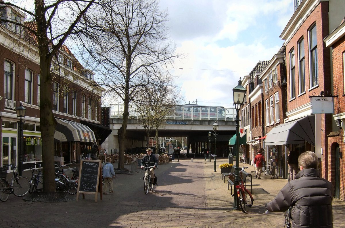The Herenstraat in the Huygenskwartier in Voorburg, with shops, terraces and the railway viaduct