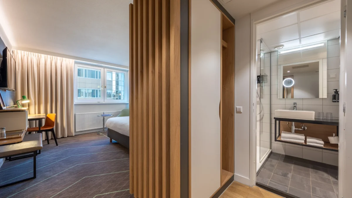 Kamer met open badkamer achter houten lamellen