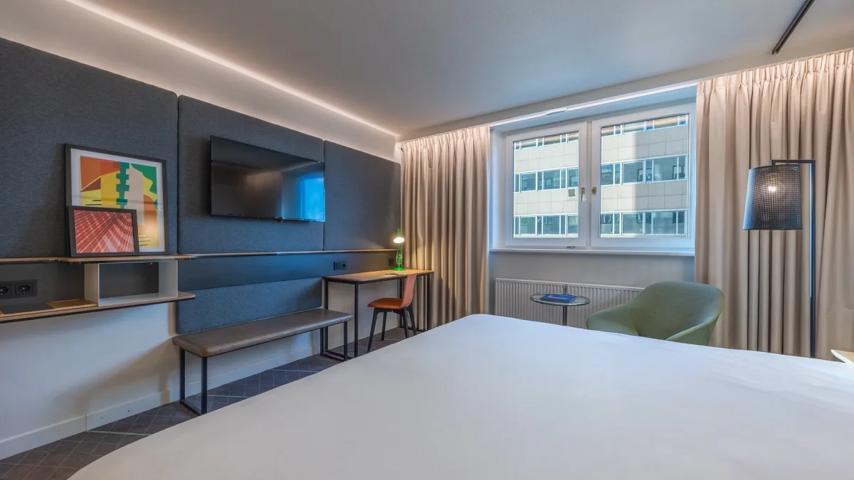 Room with a king size bed, television and work space