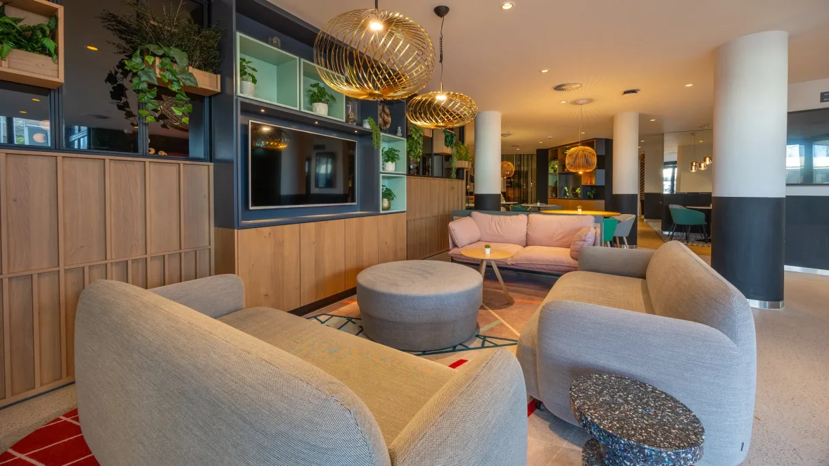 Lobby with a seating area, plants and a large screen